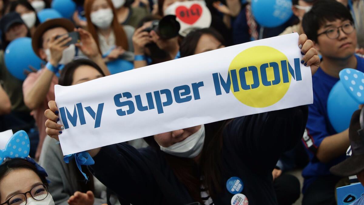 Supporters of South Korean presidential candidate Moon Jae-in of the Democratic Party of Korea, cheer during the presidential election campaign on Monday in Seoul.