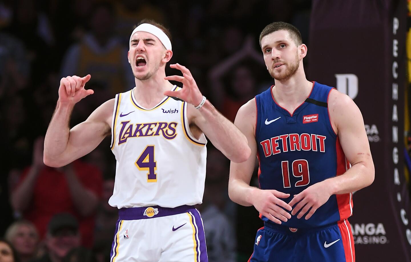 Lakers guard Alex Caruso celebrates a dunk in front of Detroit Pistons guard Svi Mykhailiuk during the fourth quarter.