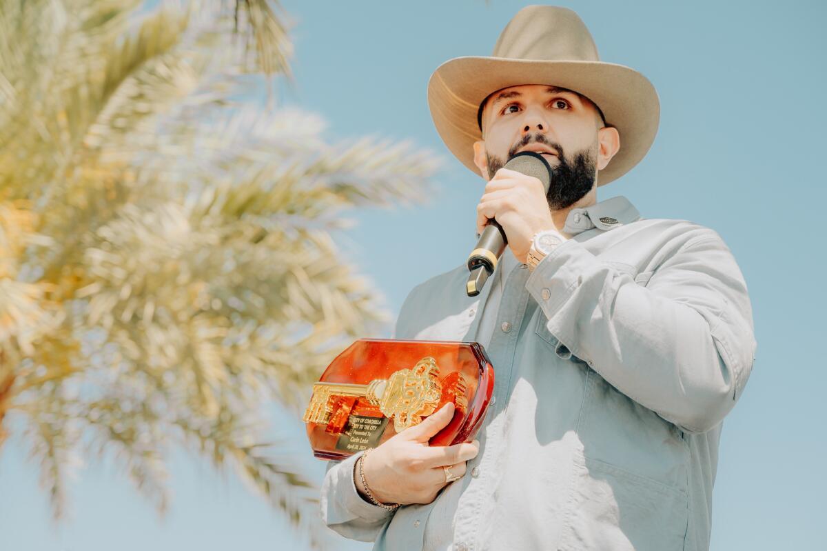 Carin León posa junto a la placa con "La Llave de la Ciudad de Coachella".