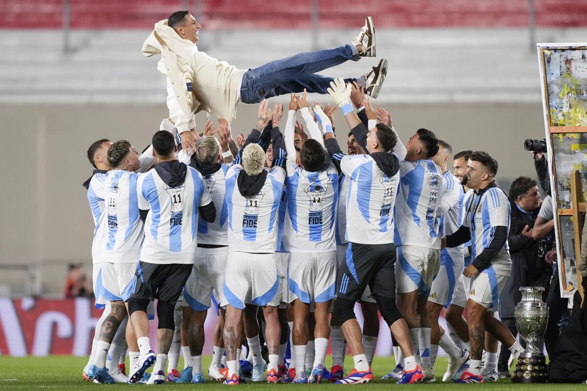 Los futbolistas de Argentina levantan a Ángel Di María en el homenaje