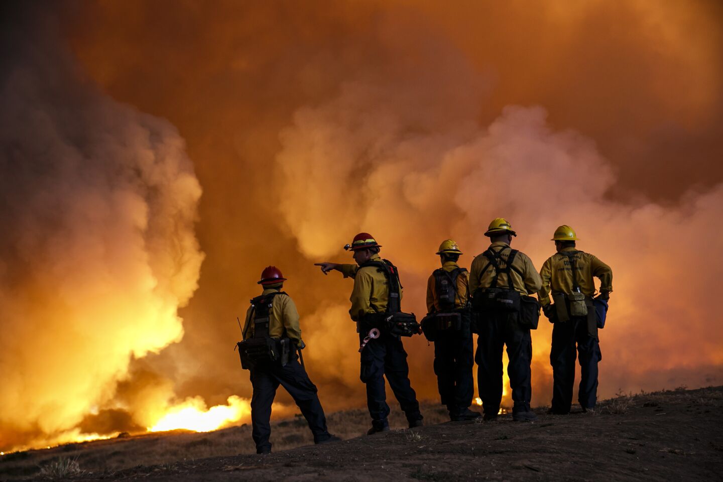 Firefighters monitor the front lines of the Sherpa Fire along Calle Real road in Goleta, Calif.