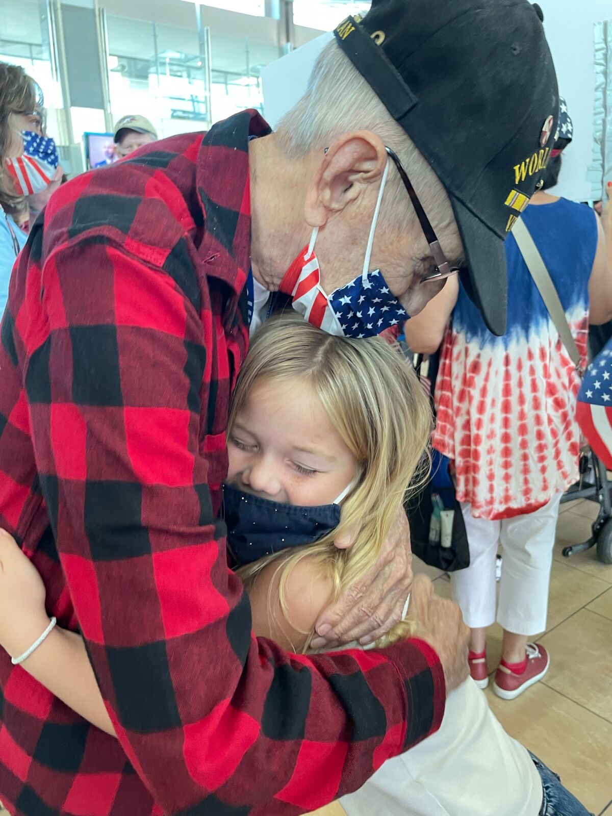 Third grader Ivy Hauenstein receives a hug from a veteran.