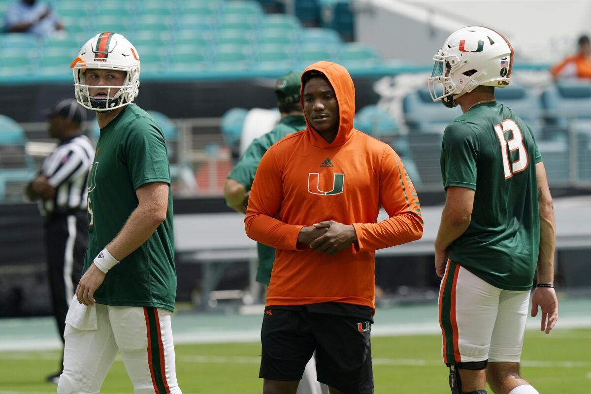 Miami starting quarterback D'Eriq King, center, stands with quarterbacks Tyler Van Dyke (9) and Jake Garcia (13) before an NCAA college football game against Central Connecticut State, Saturday, Sept. 25, 2021, in Miami Gardens, Fla. King is not playing due to an injury. (AP Photo/Lynne Sladky)