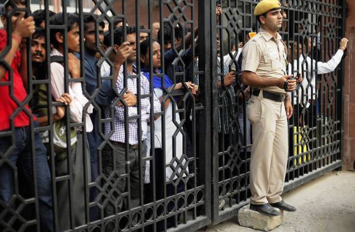 Indians behind the gates of a court complex in New Delhi watch protesters outside who were demanding that the juvenile involved in a December gang rape and murder also receive the death penalty.