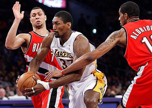 Lakers forward Ron Artest splits the defense of Portland's Brandon Roy, left, and LaMarcus Aldridge in the first quarter Sunday. Artest was on the bench for the final 2 minutes, 50 seconds of the Lakers' 91-88 loss at Staples Center.