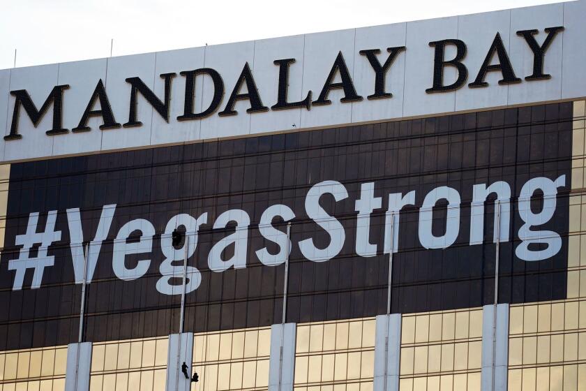 FILE - In this Monday, Oct. 16, 2017, file photo, workers install a #VegasStrong banner on the Mandalay Bay hotel and casino in Las Vegas. Stephen Paddock opened fire from the hotel on an outdoor country music concert, killing 58 and injuring hundreds. Las Vegas' efforts to rebrand itself since the shooting show just how difficult it can be for organizations to hit the right tone after a deeply tragic event. The city put its famous "What happens here, stays here" slogan on hold, and its initial ad campaign after the attack won praise for its sensitivity. But a national TV commercial that features real social media posts from after the shooting is getting more mixed reviews, with some calling it tacky.(AP Photo/John Locher, File)