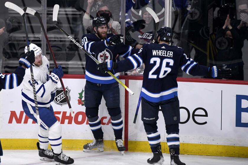 Winnipeg Jets' Pierre-Luc Dubois (80) celebrates his goal against the Toronto Maple Leafs with Blake Wheeler (26) during the first period of an NHL hockey game, Sunday, Dec. 5, 2021, in Winnipeg, Manitoba. (Fred Greenslade/The Canadian Press via AP)