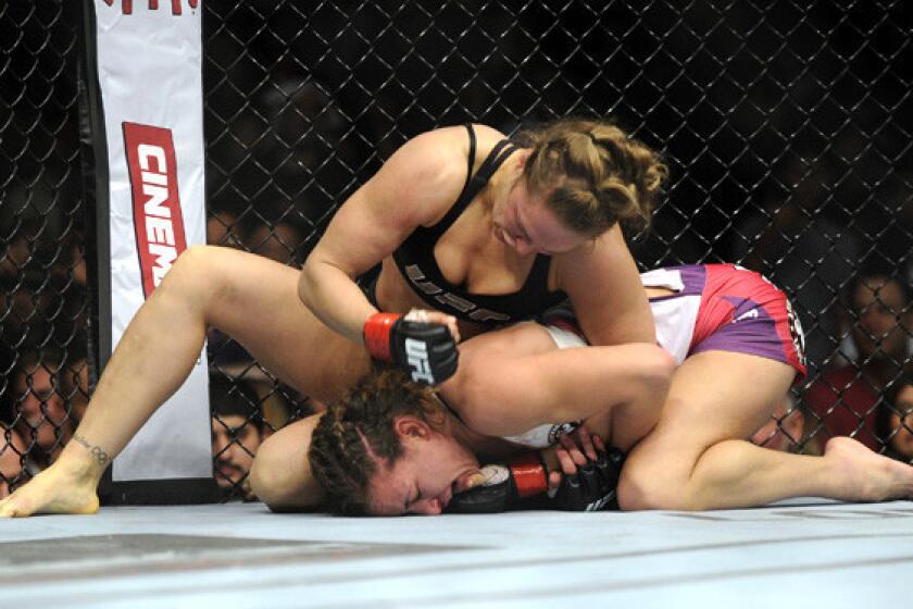 Ronda Rousey pummels Miesha Tate from the top position during their UFC 168 bantamweight title fight on Saturday night in Las Vegas.