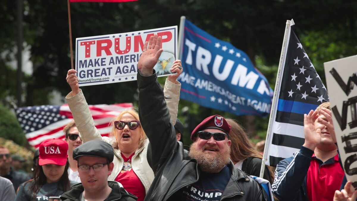 Demonstrators with Trump campaign signs and U.S. flags