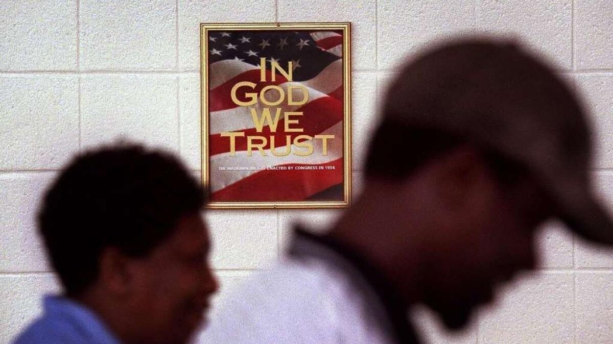 A poster with "In God We Trust" hangs in the main hallway of Larkspur Middle School in Virginia Beach, Va., in 2002.