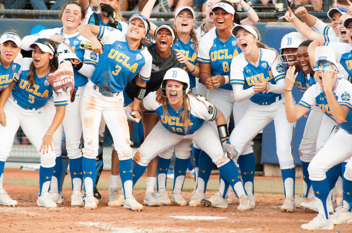 UCLA players wait for Malia Quarles at home plate after she hit a solo home run during the Bruins' 6-2 victory over Arizona in the Women's College World Series semifinals on May 31.