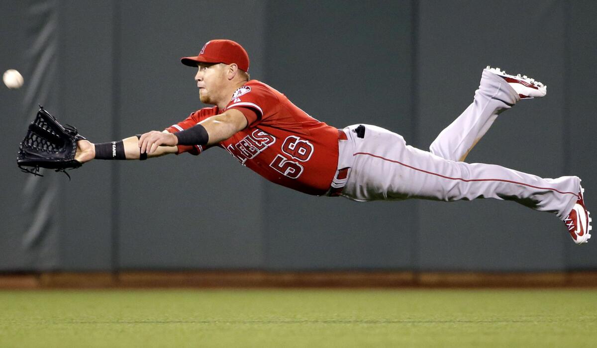 Angels right fielder Kole Calhoun makes a diving catch on a shallow fly ball hit by San Francisco's Andrew Susac during a 2-1 loss to the Giants on May 1. Calhoun will get offense help with baseman/outfielder Marc Krauss from triple-A Salt Lake, inserted into the ninth spot in the lineup against the Rockies on Tuesday.