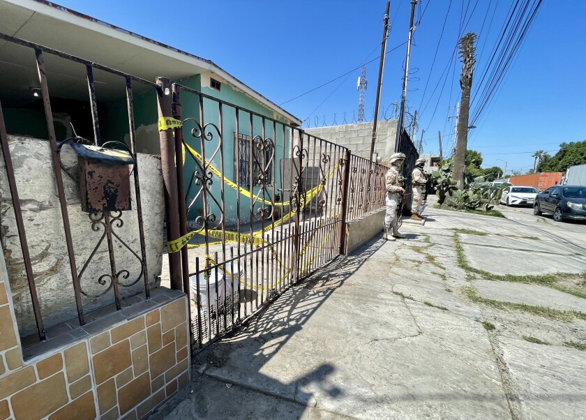Two guards stand outside a fence