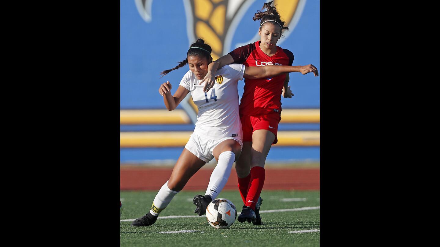 Marina High's Erika Sosa (14) battles Los Alamitos' Sophia Bruno for control of the ball during the first half in a Sunset League match on Thursday.