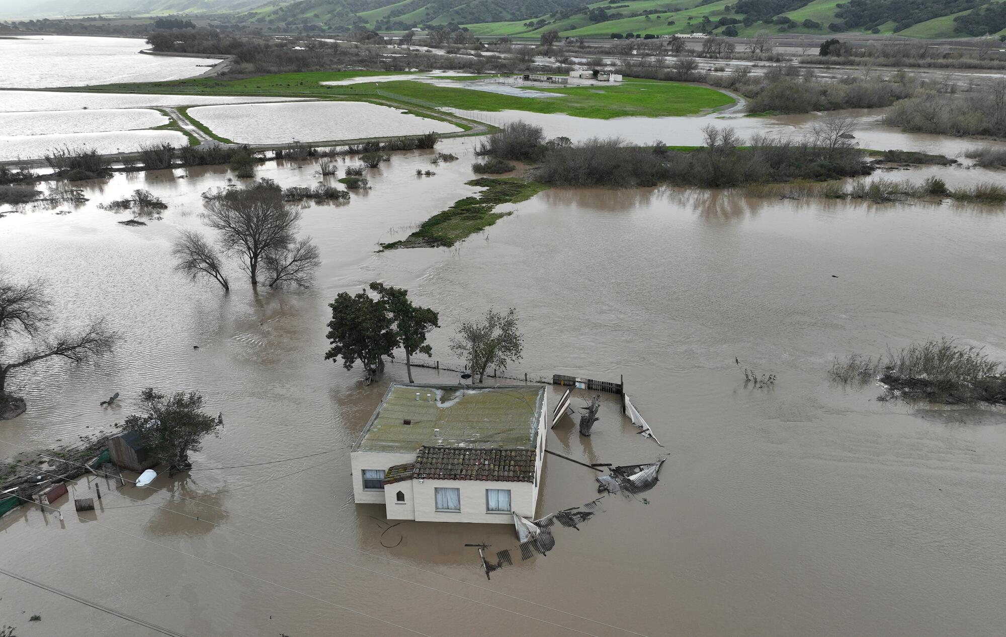 Una casa se ve sumergida en el agua de la inundación como el río Salinas comienza 