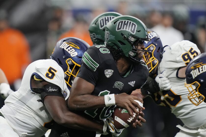 Ohio quarterback CJ Harris (10) is sacked by Toledo linebacker Nate Givhan (5) during the second half of the Mid-American Conference championship NCAA college football game, Saturday, Dec. 3, 2022, in Detroit. (AP Photo/Carlos Osorio)