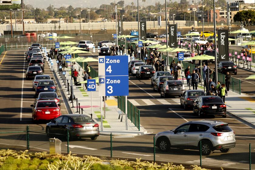 LOS ANGELES CA OCTOBER 29, 2019 — Passengers walk or can take a shuttle to the new passenger pickup lot Tuesday, October 29, 2019, the first day to connect with Uber, Lyft and taxis that are no longer allowed to pick up arriving passengers at terminals. (Al Seib / Los Angeles Times)