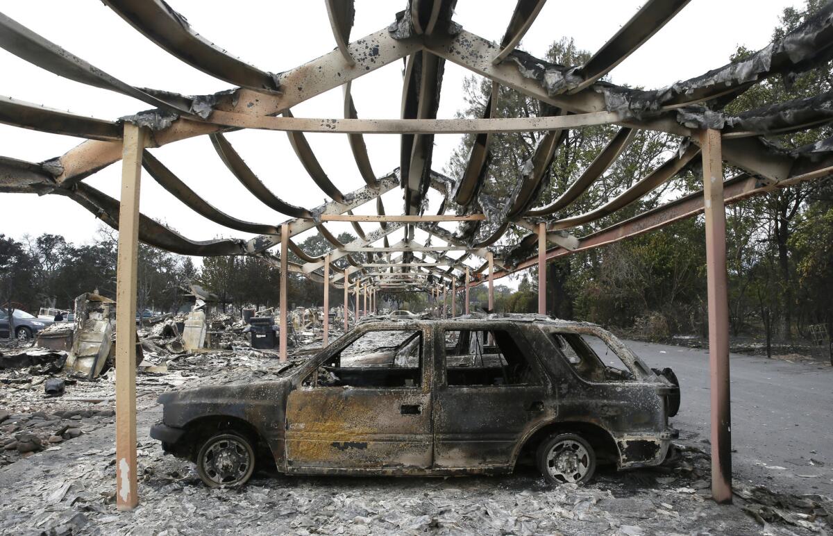 The charred metal skeleton of a carport and vehicles at the Middletown Manor apartments in Middleton, Calif. Nearly all the 1,000 citizens of the town were forced to evacuate the Valley fire.