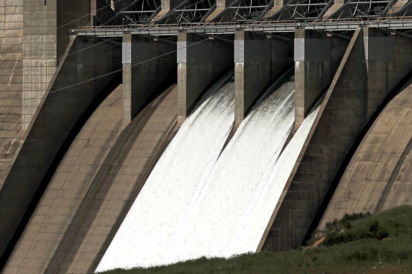 Folsom, CA - April 16: Water cascades down the face of Folsom Dam on Thursday, April 13, 2023. A series of heavy rainstorms this winter has replenished Folsom Lake, a reservoir behind the dam that stores water from the American River. The lake is currently more than 50 feet above its levels from 2022, and is about 60 percent full. (Luis Sinco / Los Angeles Times)