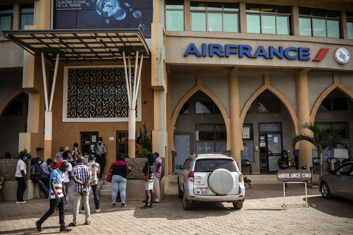People queue at the office of French airline Air France in Ouagadougou Wednesday Jan. 26, 2022. Experts say that in the wake of Burkina Faso’s coup d’etat, instability could lead to ramped up jihadist attacks as tensions between the gendarme and military may also mount. (AP Photo/Sophie Garcia)