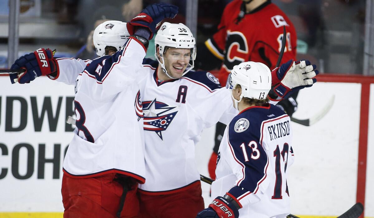 Columbus Blue Jackets' Boone Jenner, center, celebrates his goal with teammates David Savard, left, and Cam Atkinson during the first period against the Calgary Flames on Friday.