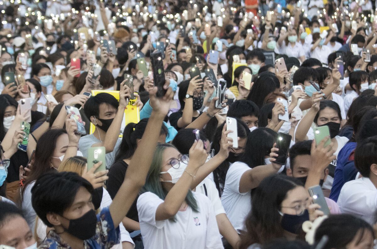 Pro-democracy students raise their mobile phones during a protest at the Thammasat University in Pathum Thani, north of Bangkok, Thailand, Monday, Aug, 10, 2020. Protesters last week warned that they'll step up pressure on the government if it failed to meet their demands, which include dissolving the parliament, holding new elections and changing the constitution. (AP Photo/Sakchai Lalit)