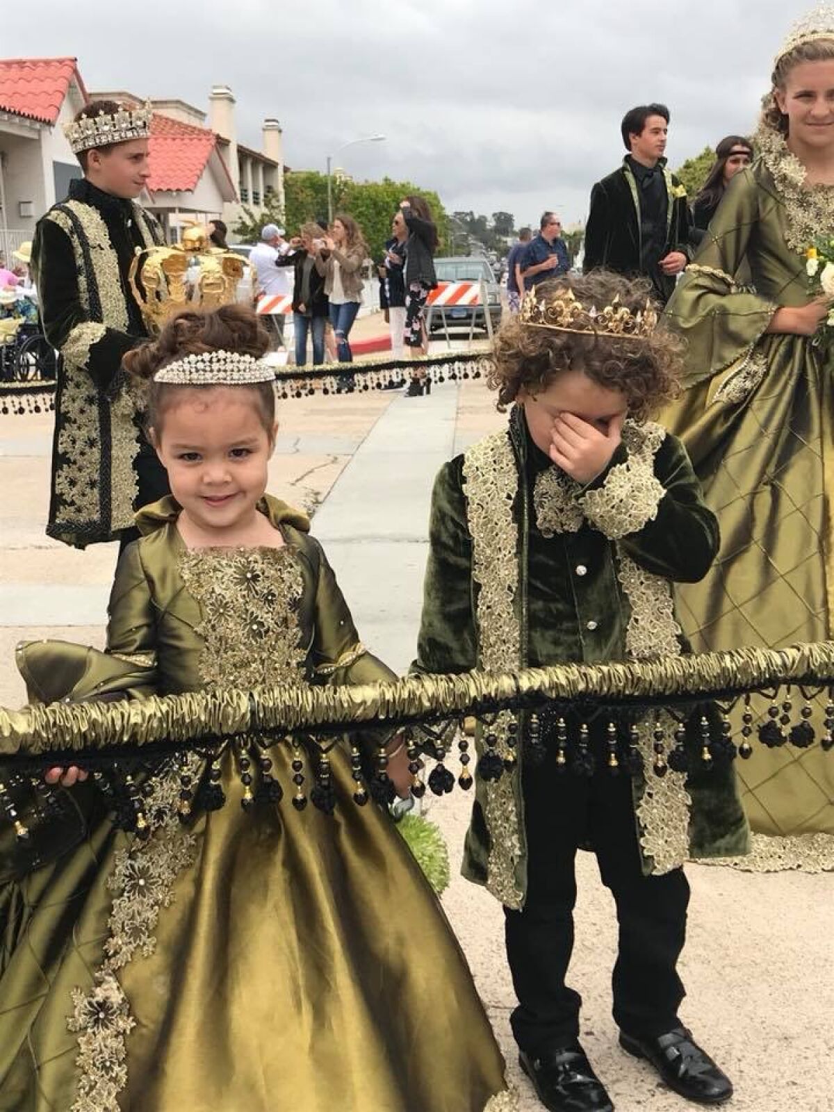 Presley Allen and J.P. Garces III seem to be experiencing the elaborate clothing of the 2018 Festa parade differently.