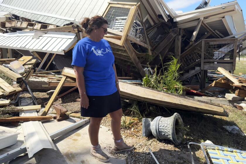 Laurie Lilliott stands amid the wreckage of her destroyed home in Dekle Beach in rural Taylor County, Fla., Friday, Sept. 27, 2024, in the aftermath of Hurricane Helene. (AP Photo/Kate Payne)