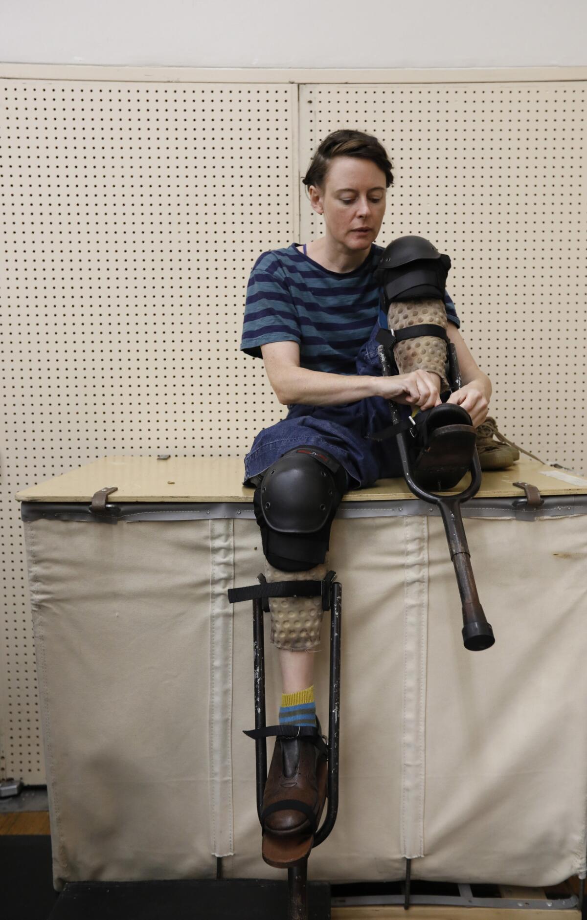 Tina Koch straps on stilts before donning one of the puppets in the opera "Satyagraha," during a rehearsal at the Dorothy Chandler Pavilion in Los Angeles.