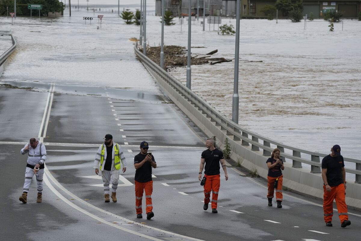 People walk on a flooded bridge