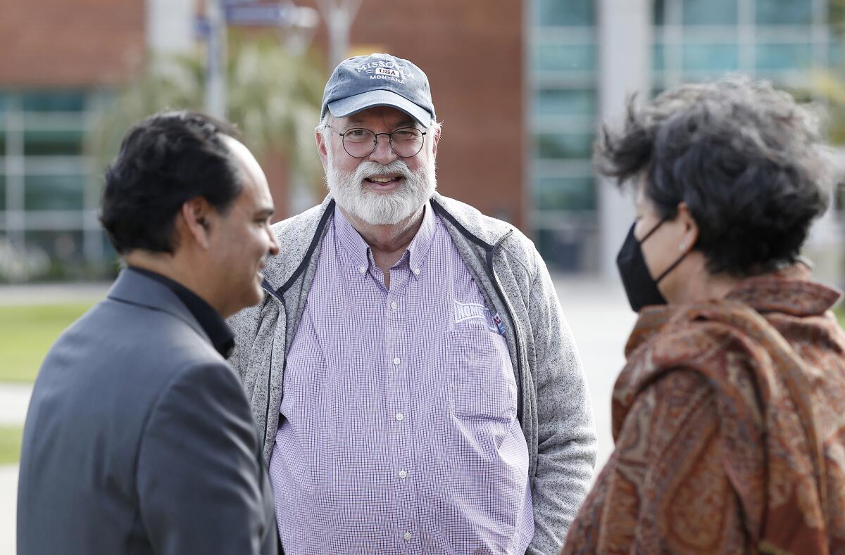 Father Greg Boyle greets facilitator Eric Cuellas outside the Global Engagement Center at Orange Coast College on Tuesday. 