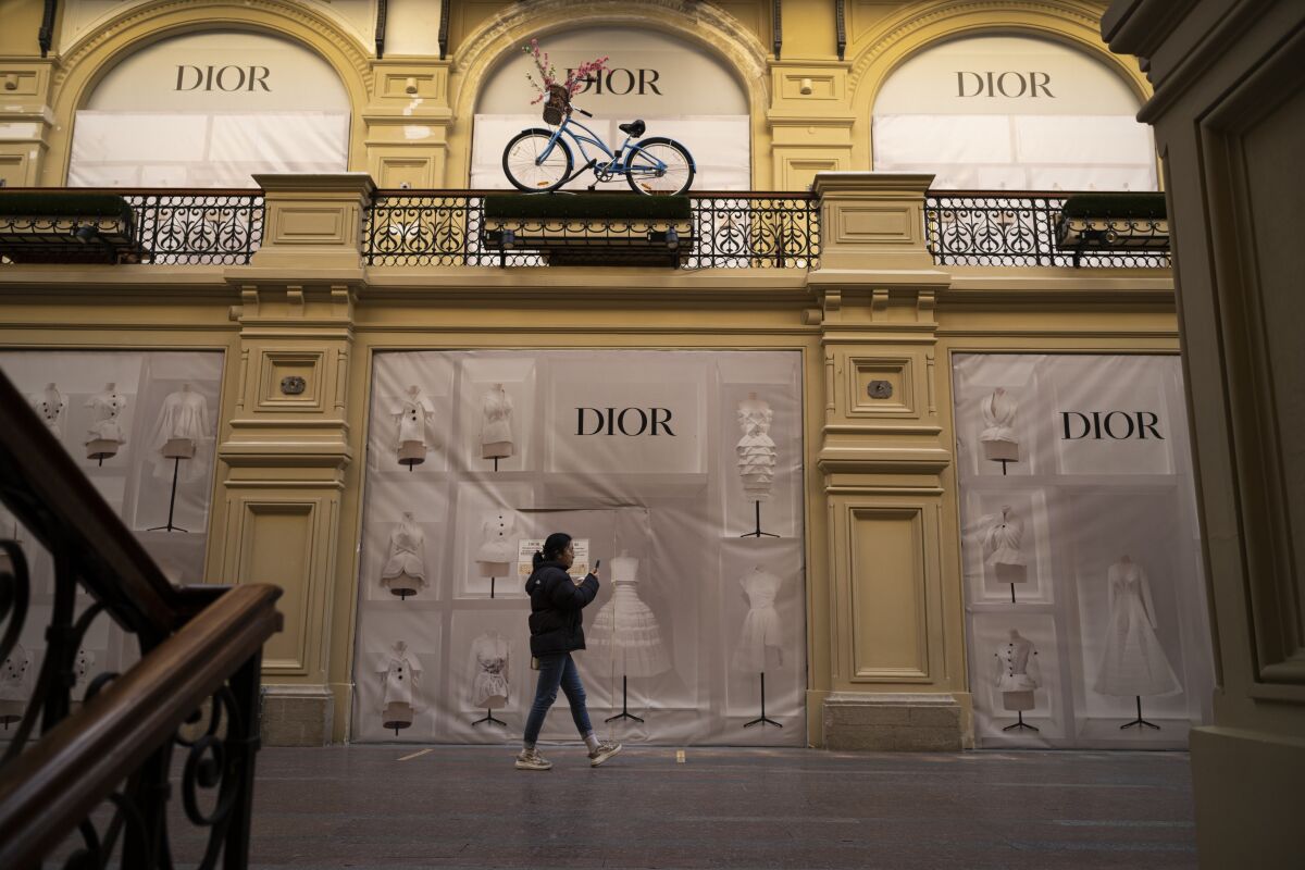 A visitor walks past a closed Dior boutique inside the GUM department store in Moscow, Russia, Wednesday, March 9, 2022. (AP Photo)