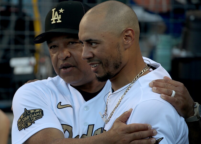 Dodgers manager Dave Roberts and outfielder Mookie Betts embrace in the dugout during the All-Star Game.