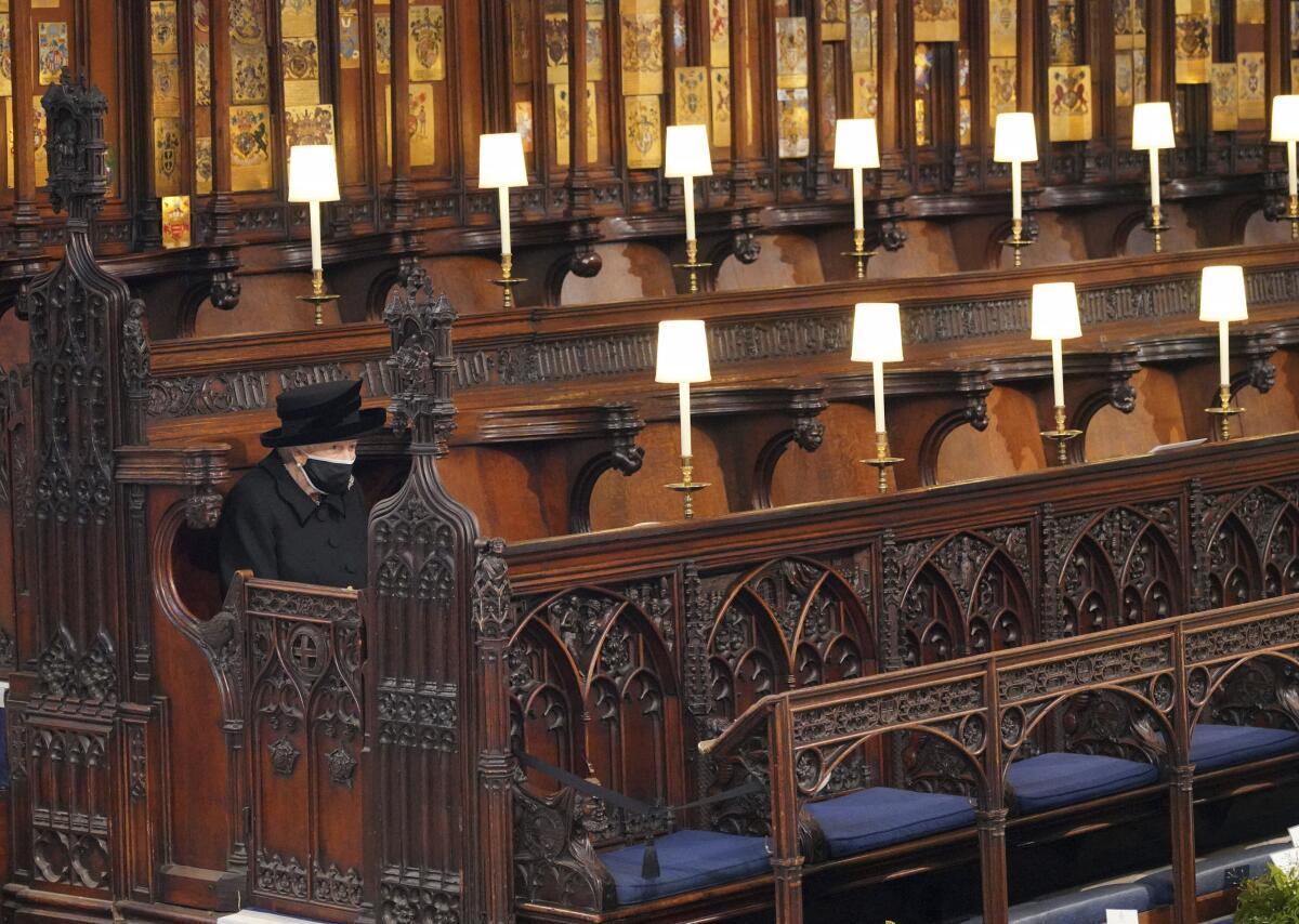 Britain's Queen Elizabeth II sits alone in St. George's Chapel during the funeral of Prince Philip.