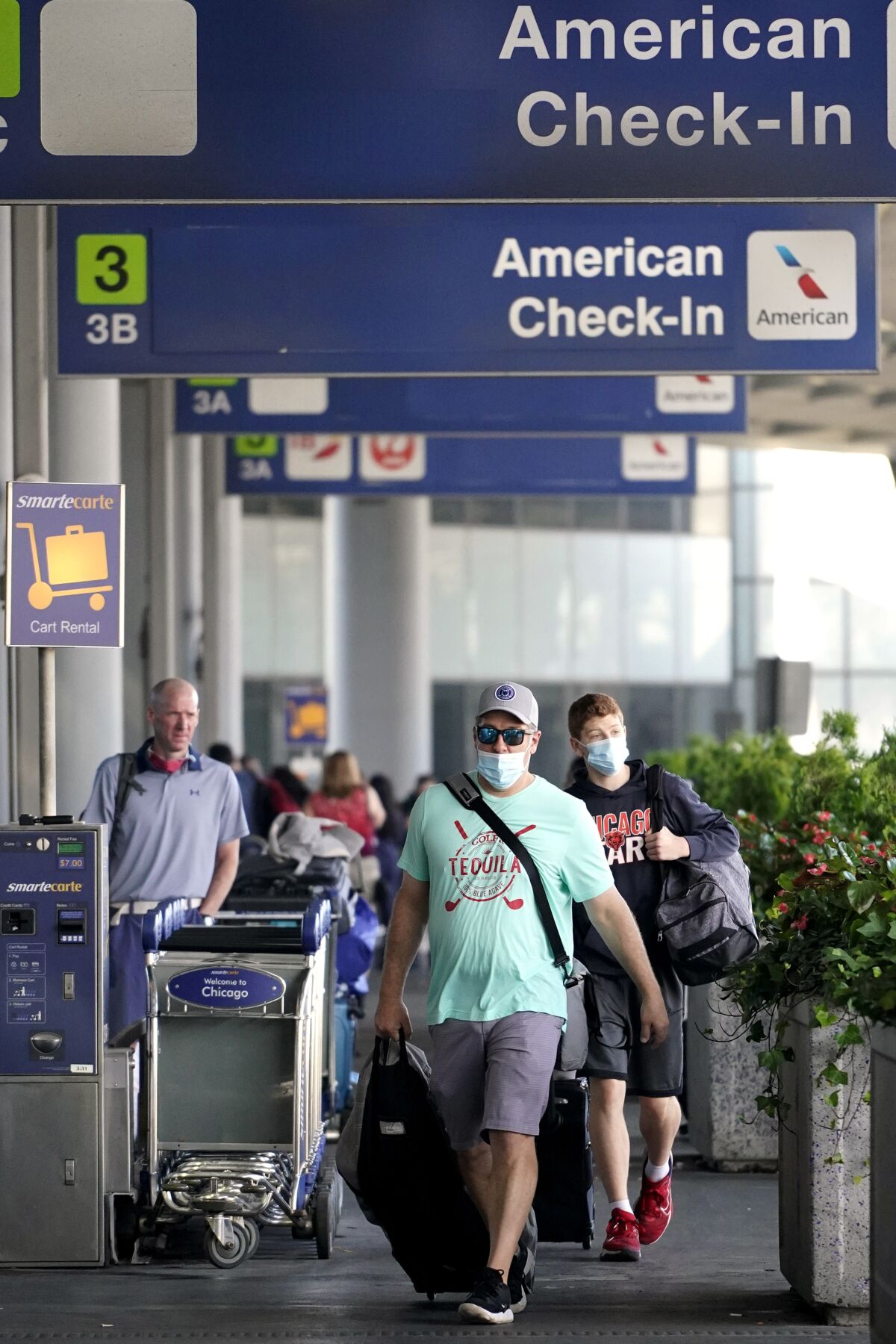 Travelers walk through Terminal 3 at Chicago's O'Hare International Airport ahead of the Fourth of July weekend, Friday, July 2, 2021. American Airlines says the July Fourth holiday weekend was a hit, with nearly three times as many people flying on the airline than did over the holiday weekend last year. (AP Photo/Nam Y. Huh)