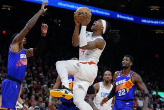 Los Angeles Clippers' Terance Mann (14) drives to the basket between Phoenix Suns' Torrey Craig, left, and Deandre Ayton during the first half of an NBA basketball game Thursday, Feb. 16, 2023, in Phoenix. (AP Photo/Darryl Webb)