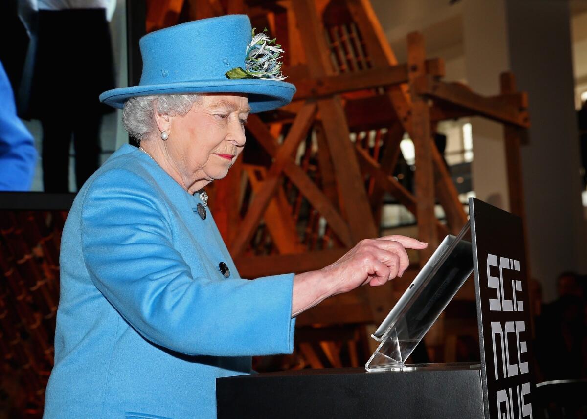Britain's Queen Elizabeth II sends her first tweet at the opening of the "Information Age" exhibition at London's Science Museum on Oct. 24.
