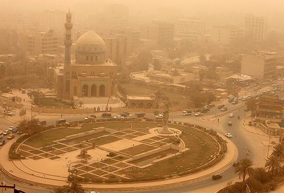 A dust storm obscures Firdos Square in central Baghdad. Some officials say Iraq is in the throes of an environmental catastrophe, with more frequent dust storms only the most visible manifestation.