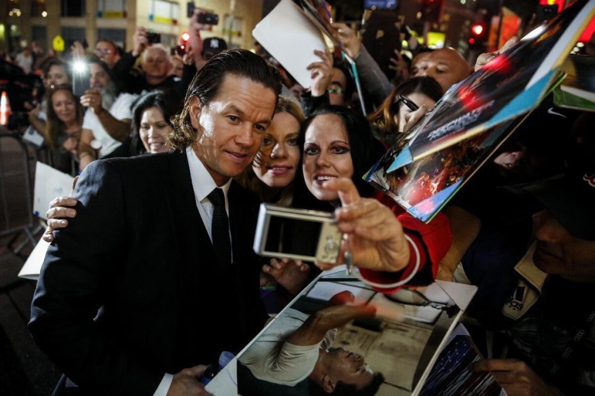 Mark Wahlberg signs autographs and takes pictures with fans at Thursday's premiere of "Patriots Day" at the TCL Chinese Theatre in Hollywood during the AFI Fest.