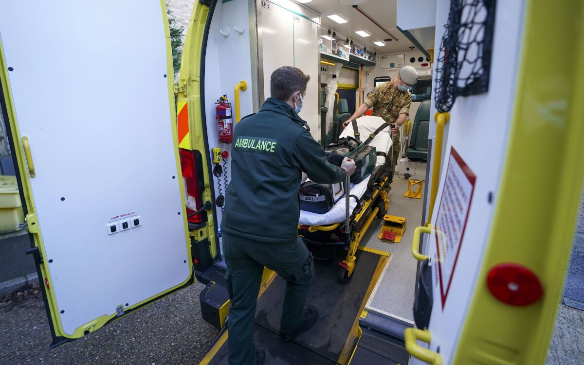 Military co-responders Lt. Corydon Morrell, background and Major James Allen board an ambulance, at the NHS South Central Ambulance Service Bracknell Ambulance Station in Bracknell, England, Wednesday, Jan. 12, 2022, where the military personnel are being used to supplement the NHS during staffing shortages resulting from increased isolation due to the Omicron COVID-19 variant. (Steve Parsons PA via AP)