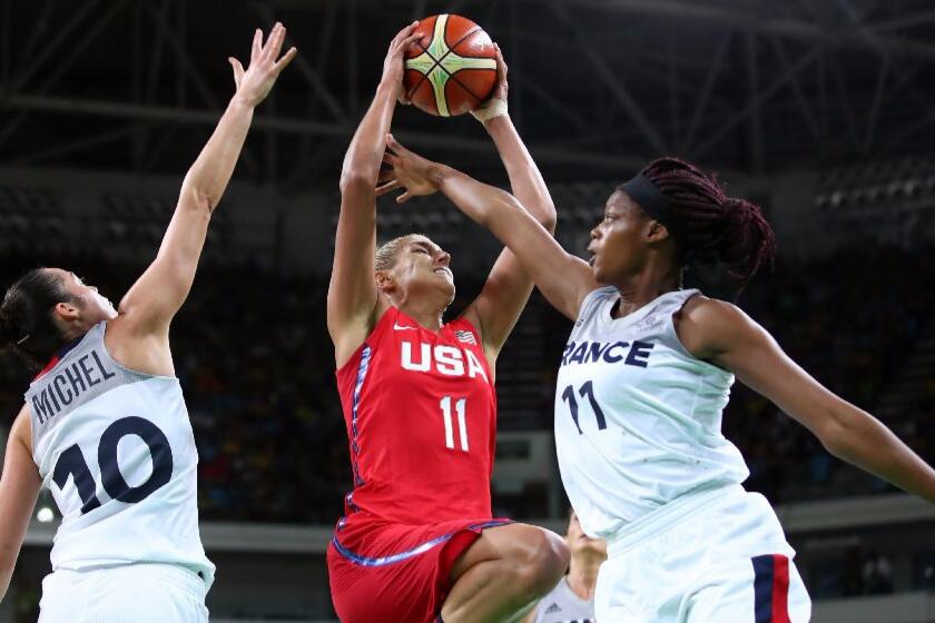 The United States' Elena Delle Donne, center, drives to the basket against French players Sarah Michel, left, and Valeriane Ayayi during Thursday's game.