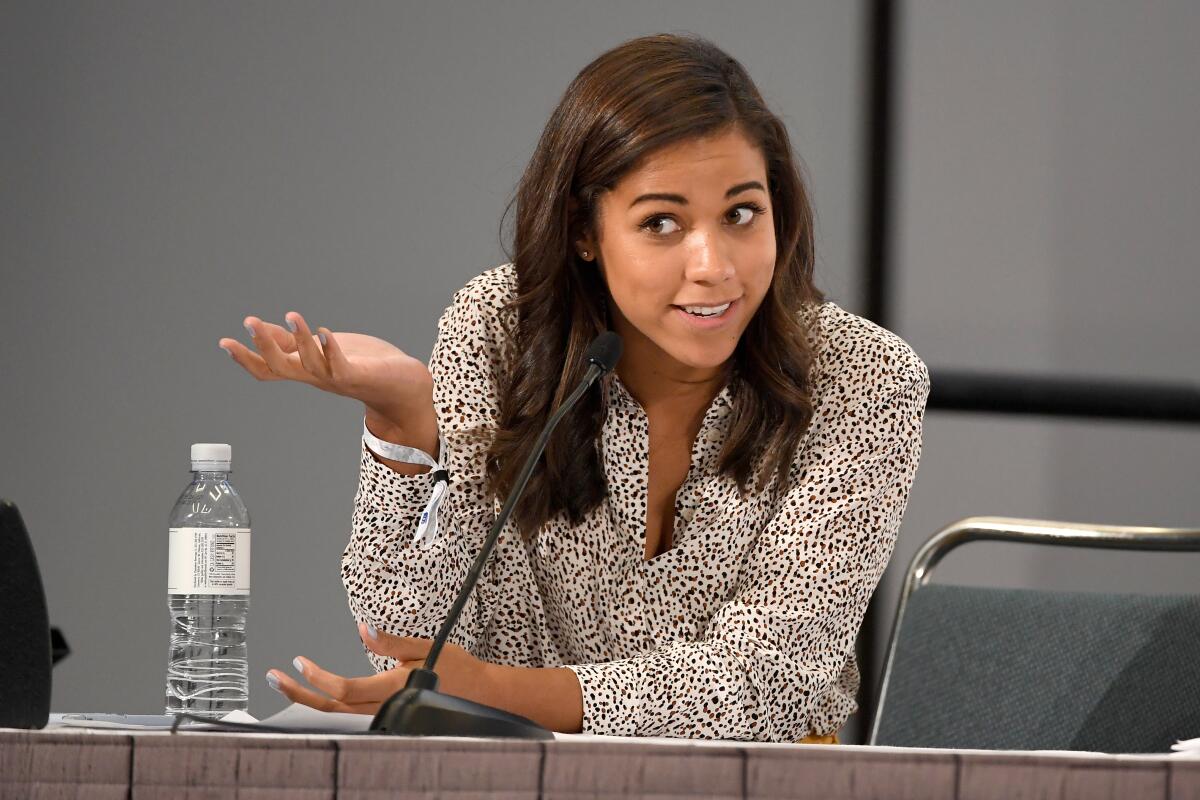 Alexi McCammond speaks while sitting at a table in 2018.