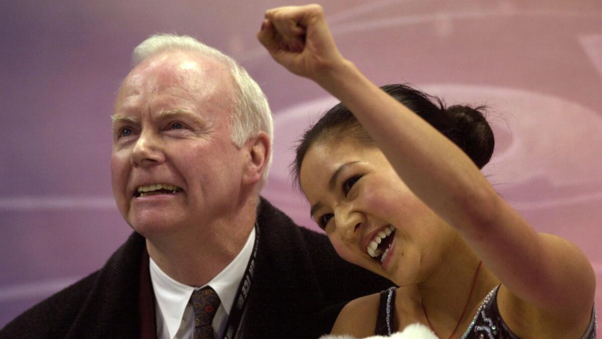 Frank Carroll and Michelle Kwan react to her scores after the women's short program at the 2001 U.S. figure skating championships. Carroll retired in August after more than 50 years as a figure skating coach.