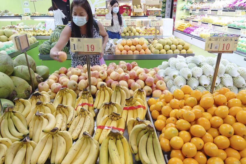FILE - Customers buy fruit at a stall in Taipei, Taiwan, Sept. 20, 2021. China has blocked imports of citrus and fish from Taiwan in retaliation for a visit to the self-ruled island by a top American lawmaker but avoided sanctions on Taiwanese processor chips for Chinese assemblers of smartphones and other electronics, a step that would send shockwaves through the global economy. (AP Photo/Chiang Ying-ying, File)