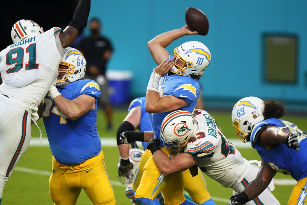  Chargers quarterback Justin Herbert (10) attempts to throw a pass under pressure from Miami Dolphins defense,