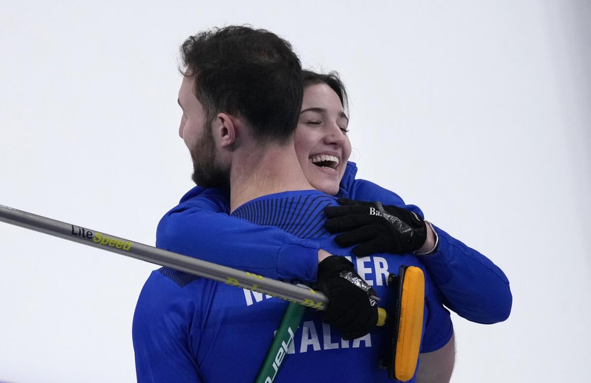 Italy's Stefania Constantini and Amos Mosaner hug after winning the mixed doubles gold medal final against Norway.