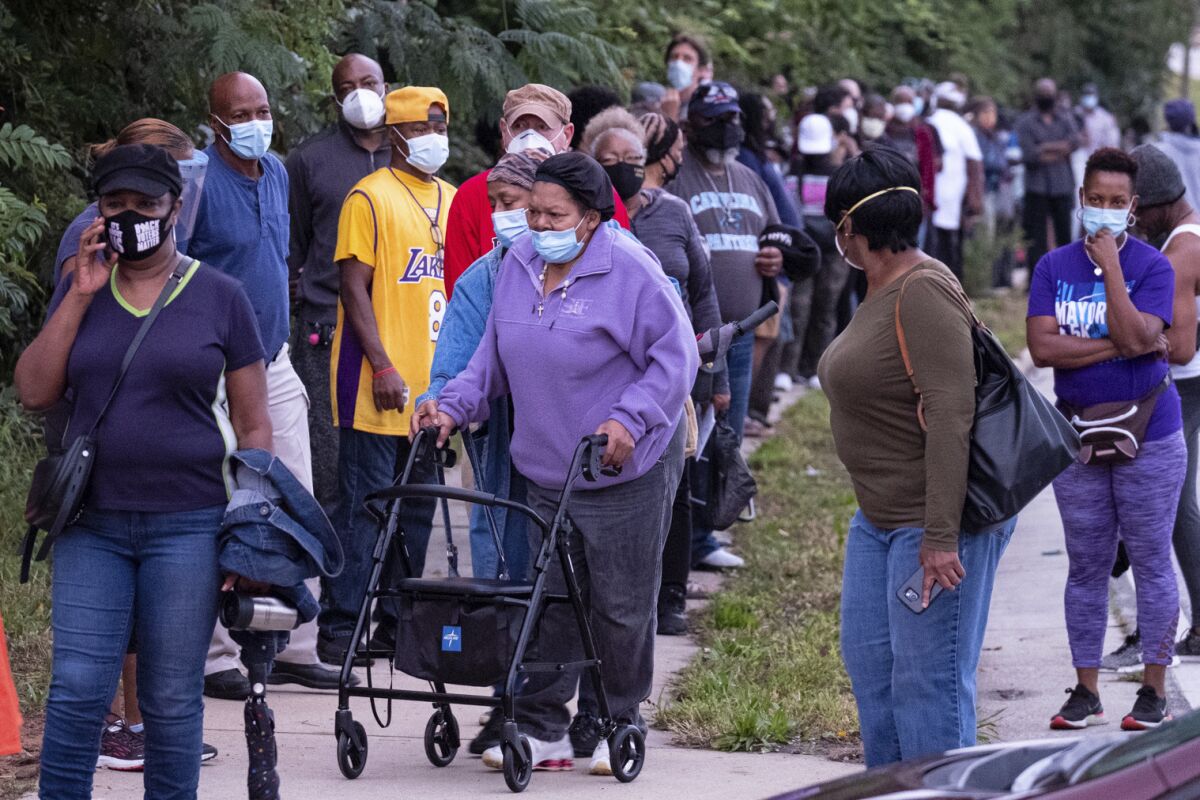 People wait in line to vote in Decatur, Ga., Monday, Oct. 12, 2020.  