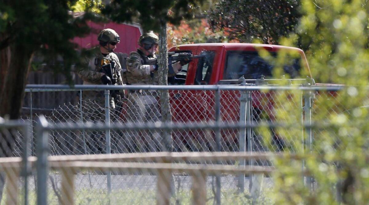FBI agents break windows of a vehicle parked outside the Pflugerville, Texas, home of Mark Conditt, who was identified as the Austin serial bomber.