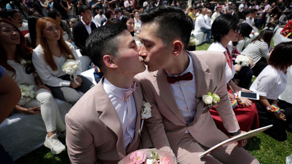 A newly married couple kiss on May 24, 2019, the first day of civil registration for same-sex marriage in Taipei, Taiwan.