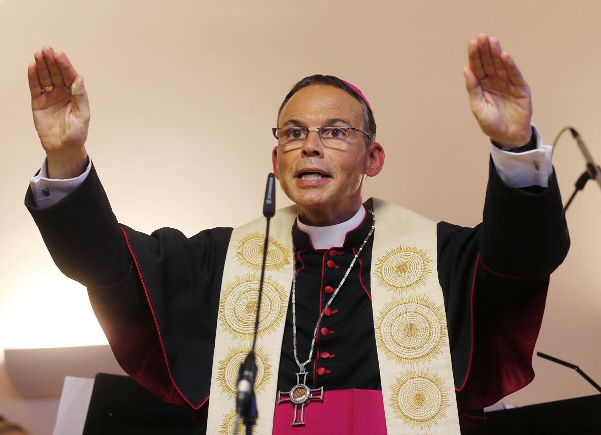 German Bishop Franz-Peter Tebartz-van Elst of Limburg, shown in this August photo blessing a new kindergarten in Frankfurt, was suspended by Pope Francis on Wednesday as the Vatican investigates a scandal over his lavish spending on trips, cars and a $42-million palatial residence renovation.